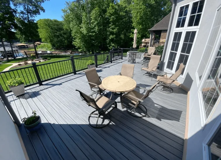 Two-tone composite deck in gray and charcoal with black metal railing and patio furniture